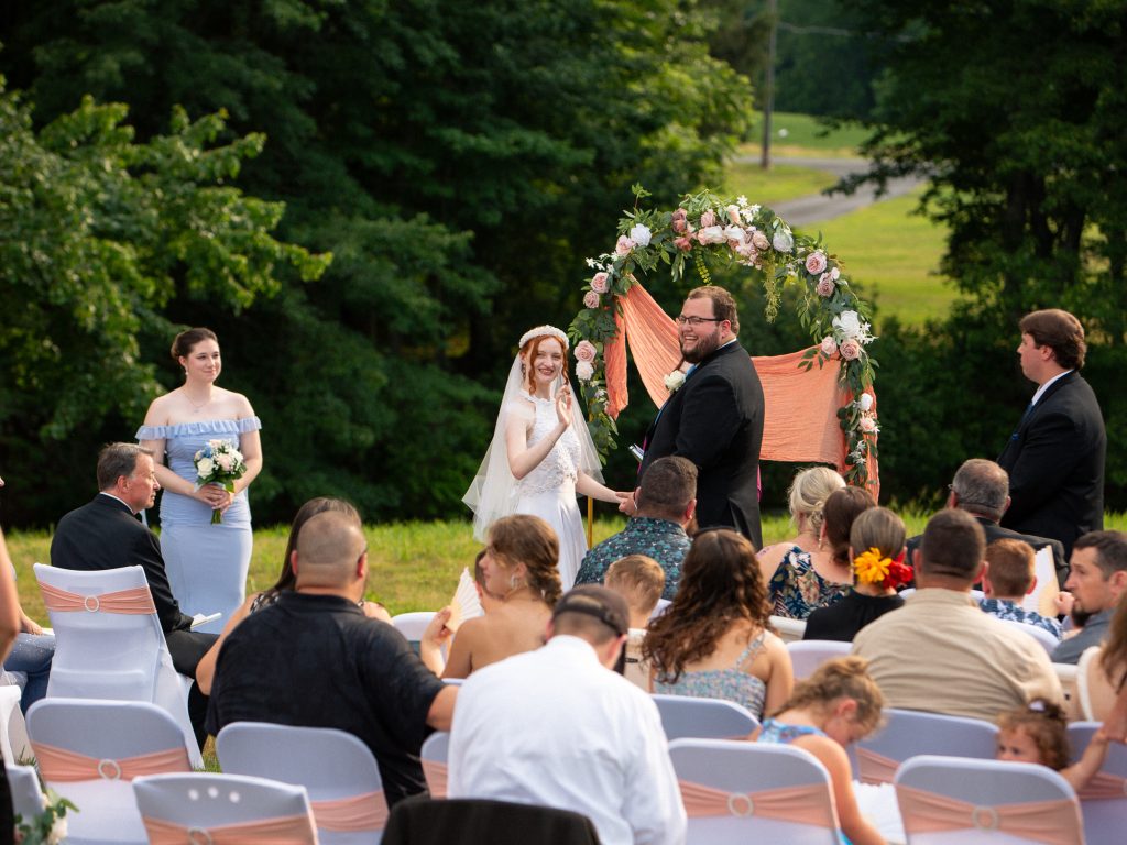 bride and groom waving during wedding ceremony