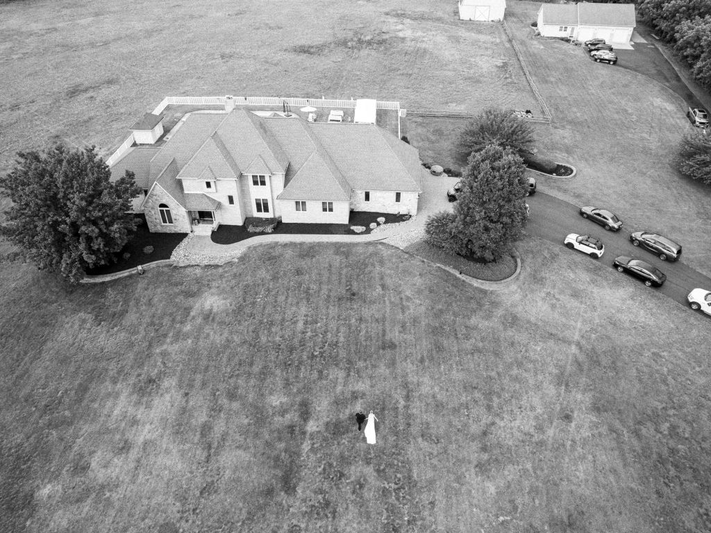 drone photo of bride and groom walking after being married