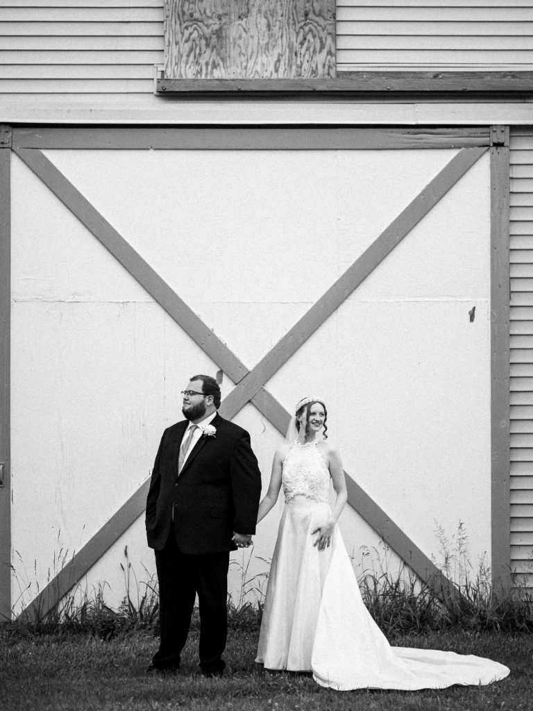 bride and groom in front of a barn
